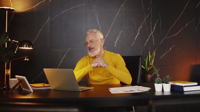 Middle-aged manager feeling annoyed while working on a laptop, software bugs