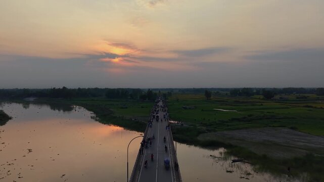 Aerial drone view of a busy bridge at sunset with traffic and river reflections serene landscape
