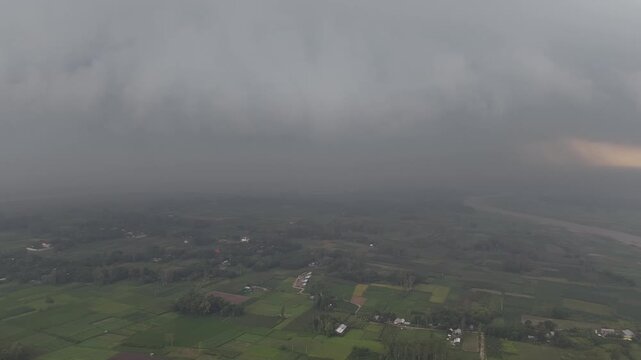 Approaching storm clouds over rural landscape aerial view dramatic weather change over farmland