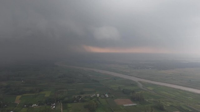 Approaching storm clouds over rural landscape river valley aerial view dramatic weather change