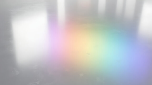 Abstract background with soft rainbow light reflections on a smooth grey surface.