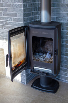 Retro wood burning stove with open door inside countryside home interior