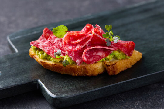Traditional spanish tapas with cured salami meat fresh vegetables and green herbs side view. Close up.