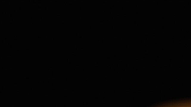 Warm orange light leak overlay with soft glow and smooth fade on a seamless black background