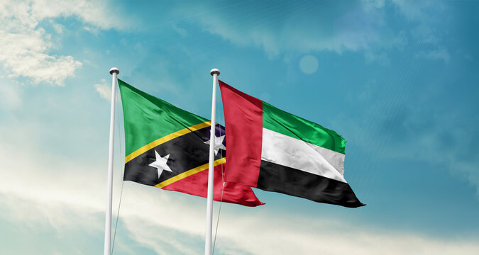 Saint Kitts and Nevis and UAE friendship flags are waving in the sky. Double country Flag waving with mast. Saint Kitts and Nevis UAE national flag for agreement.