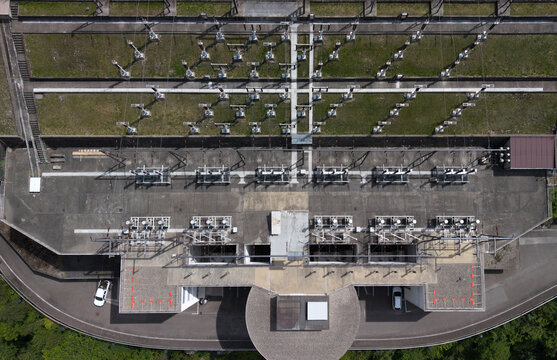 Aerial view of the Contra Dam of Verzasca Hydroelectric Power Station showing substation infrastructure, transformers, and concrete structures in Tenero-Contra, Ticino, Switzerland.