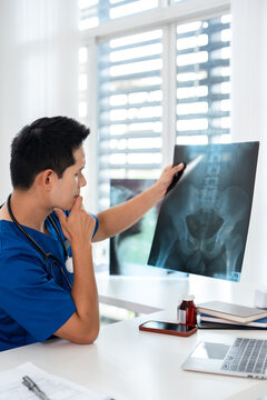 Doctor radiology  holding x-ray film , reviewing patient diagnosis results in clinic.