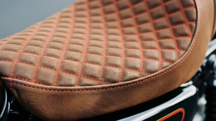 Obraz premium High-quality custom motorcycle seat, brown leather with intricate red diamond stitching.