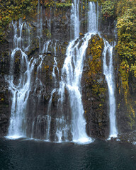 Multi-tiered waterfall cascading through a lush forest © Johann