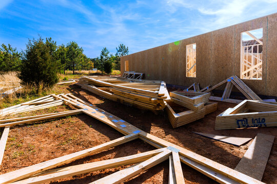 Wooden beams litter construction site as building wall begins to rise under construction