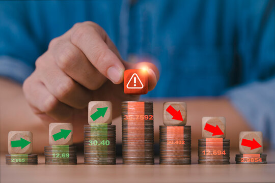 Financial risk and economic crisis concept with stacked coins and warning symbol for rising and falling trends represent market volatility, recession, inflation, investment uncertainty and instability