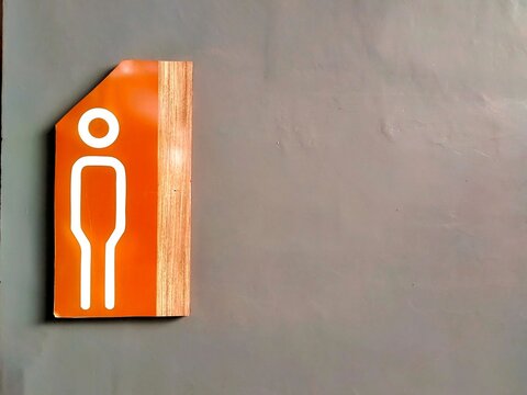 Male Toilet Direction Sign on Interior Wall with Orange and Wood Design