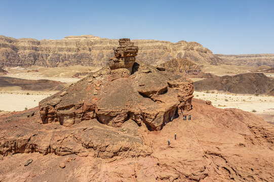 Aerial view of the iconic Mushroom rock formation in Timna Park, surrounded by rugged red sandstone desert terrain, with people exploring in Eilat, South District, Israel.