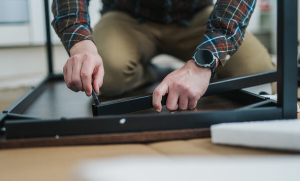 Assembling flat-pack table at home, following instructions step by step carefully