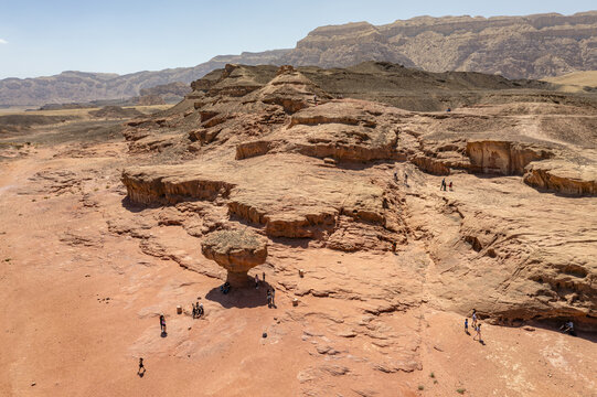 Aerial view of the Mushroom rock formation in Timna Park, featuring red sandstone desert terrain with visitors exploring the area in Eilat, South District, Israel.