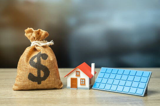 Dollar money bag and a house with solar panels. Profit from home power generation. Green tariff. Subsidies and grants for the purchase of autonomous home systems.
