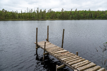 Obraz premium Wooden jetty on a lake with a forest on the shore