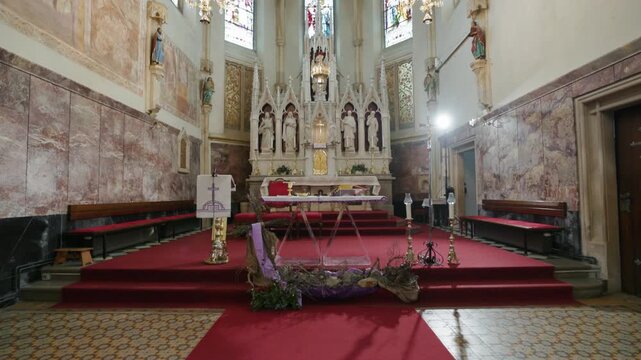 Altar and communion table with sacred vessels before a religious ceremony at a historic church with wooden pews and beautiful architecture.
