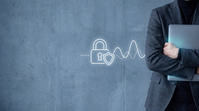 Businessman holding laptop with digital security icon. Cyber protection and data safety.
