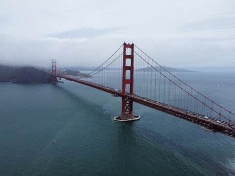 Aerial view of the Golden Gate Bridge spanning the bay under a cloudy sky in San Francisco, California, United States.