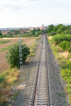 Railway Tracks Leading Toward City Skyline From Rural Countryside Perspective