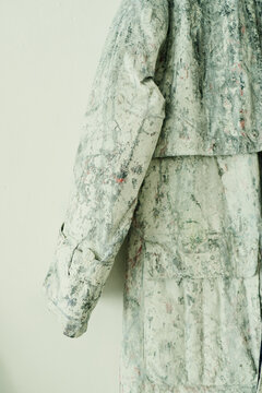 Vertical shot of contemporary artist garment displaying textured painted fabric and handcrafted design details. Supporting fashion branding, editorial features, gallery promotion, vertical