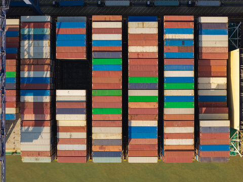 Aerial view of stacked colorful shipping containers on a cargo ship deck with geometric patterns and industrial textures United Kingdom.