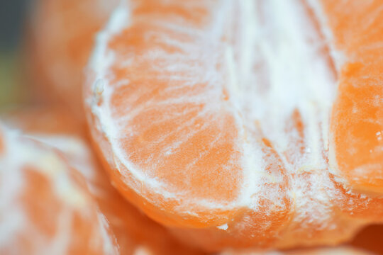 Macro close-up shot of peeled ripe tangerine segments showing juicy texture and white pith
