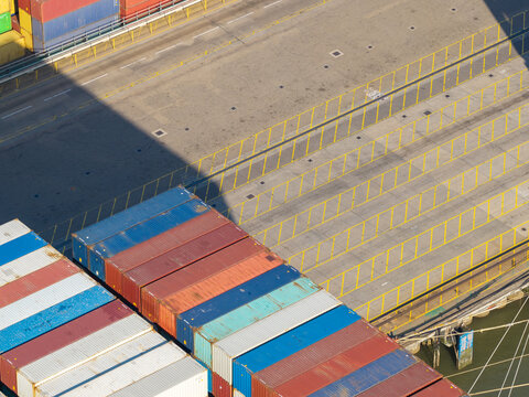 Aerial view of colorful shipping containers stacked at a busy industrial port terminal in the United Kingdom.