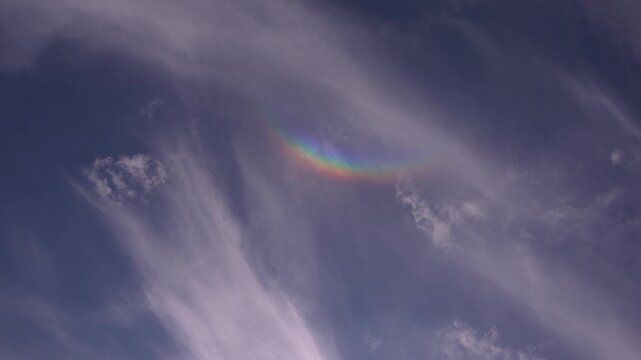 A rare atmospheric phenomenon featuring colorful cloud iridescence forming a rainbow-like arc high in the sky near the zenith in September.