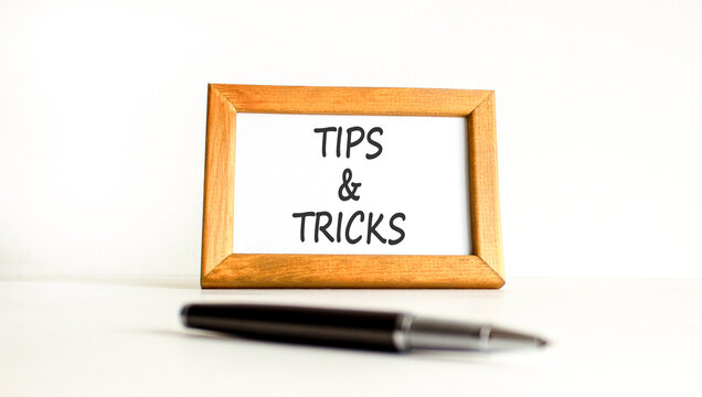 Tips and tricks words symbol. Concept words Tips and tricks on beautiful wooden picture frame. Beautiful white background. Business tips and tricks motivational support concept. Copy space.