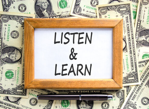 Listen and learn words symbol. Concept words Listen and learn on beautiful wooden picture frame. Beautiful dollar bills background. Dollar bills. Business listen and learn support concept. Copy space.