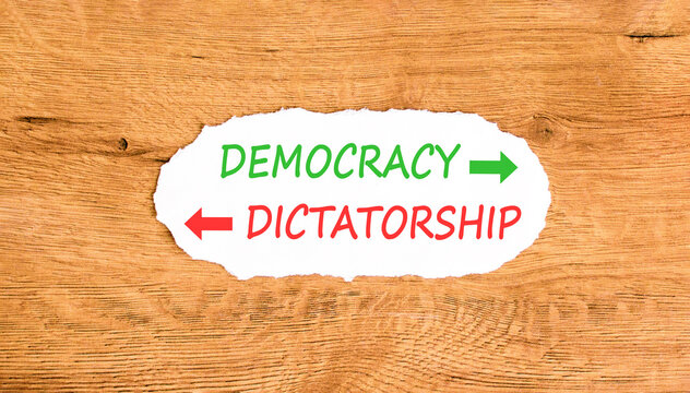 Democracy or dictatorship words symbol. Concept words Democracy Dictatorship on beautiful white paper. Beautiful wooden background. Business democracy dictatorship concept. Copy space