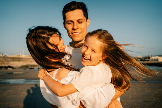 Family Enjoys Time Together on Beach During Sunny Day
