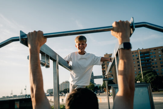 Young Boy Enjoys Outdoor Workout With Adult in City Park