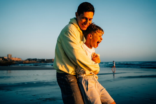 Father and Son Enjoy Time Together on the Beach at Sunset