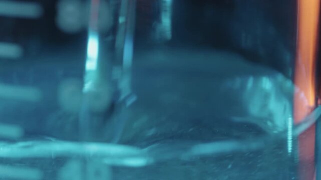 Stirring Liquid Solution with Glass Rod in Beaker for Laboratory Experiment, Macro Shot
