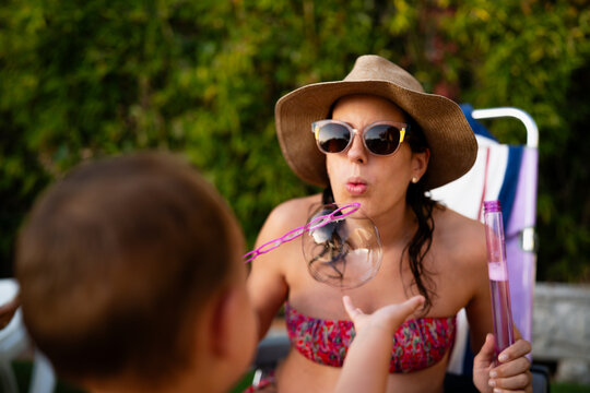 Mother and son blowing bubbles creating fun moment