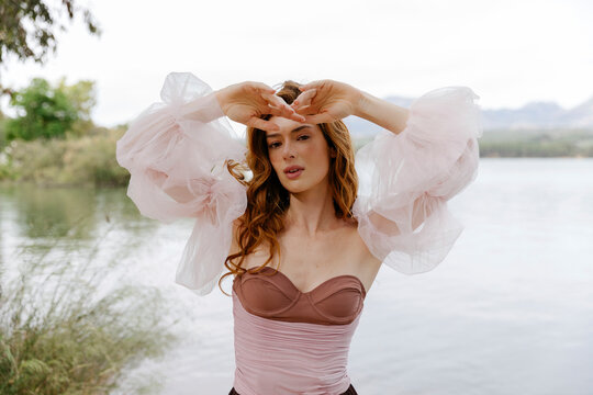 Woman posing outdoors with sheer pink sleeves