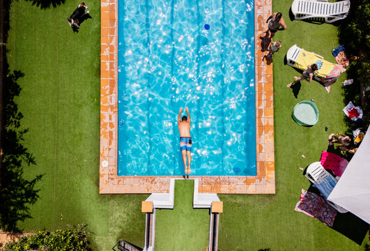 Man swimming in backyard pool