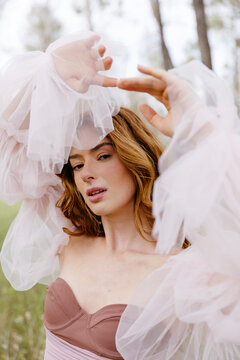 Woman with red hair in ethereal tulle dress