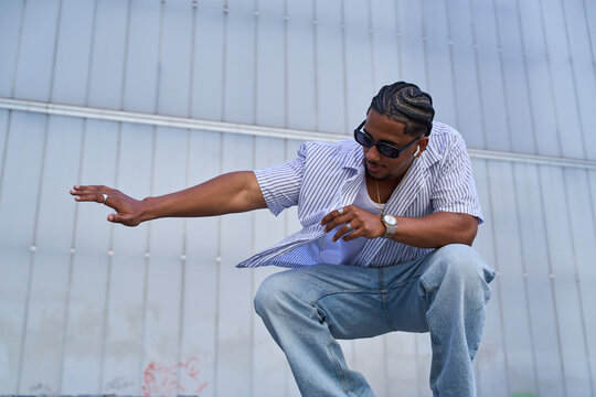 Young black man posing wearing sunglasses outdoors