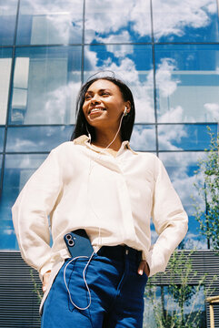woman with blue smartphone and earphones  glass building film photo