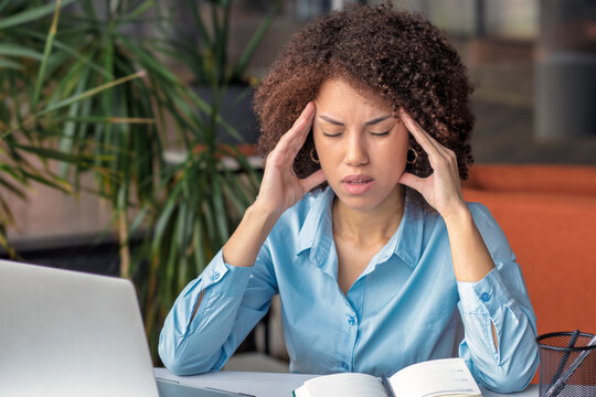 Stressed black businesswoman having a painful headache