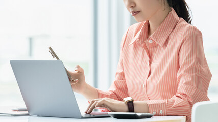 スマートフォンとノートパソコンを使う女性・ビジネスウーマン, Businesswoman Using a Smartphone and Laptop © Trickster*