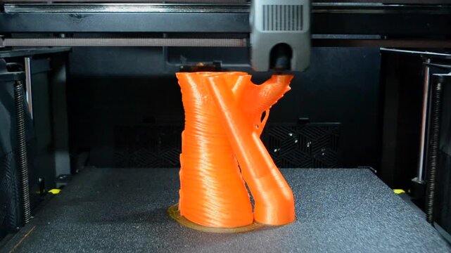 Process printing on 3D printer. The 3D printing process from molten plastic orange color. 3D printing technology. FDM technologies. Fused Deposition Modeling. Additive manufacturing.
