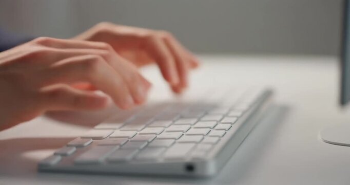 Person using a wireless keyboard to complete work tasks in dark workspace