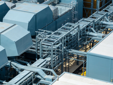 Aerial view of a data center rooftop featuring industrial cooling units and complex metal cable tray infrastructure in the United Kingdom.