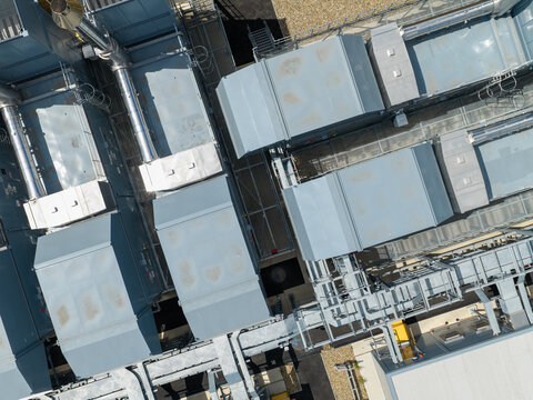 Aerial view of a data center roof featuring industrial HVAC units, ventilation systems, and metal piping in the United Kingdom.