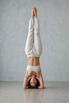 Strong woman balancing upside down in headstand for core fitness and mindfulness